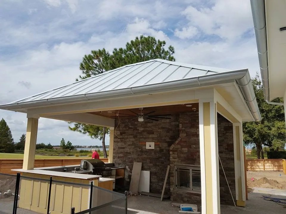 Outdoor kitchen pavilion metal roof half round gutters stone fireplace, Sanford